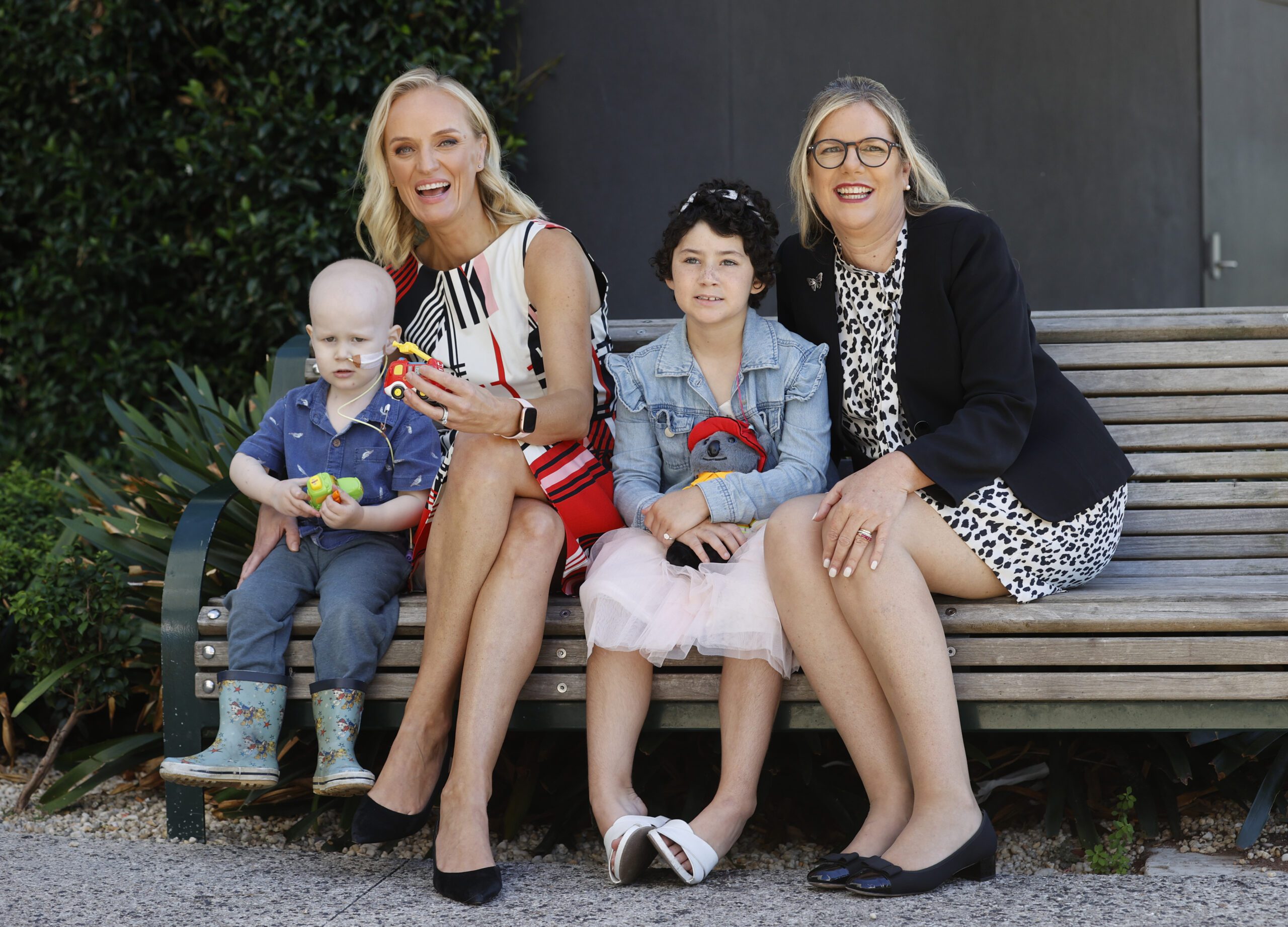 Appeal director Rebecca Cowan and Chairman Penny Fowler sitting on a bench seat with children Alex and Isla