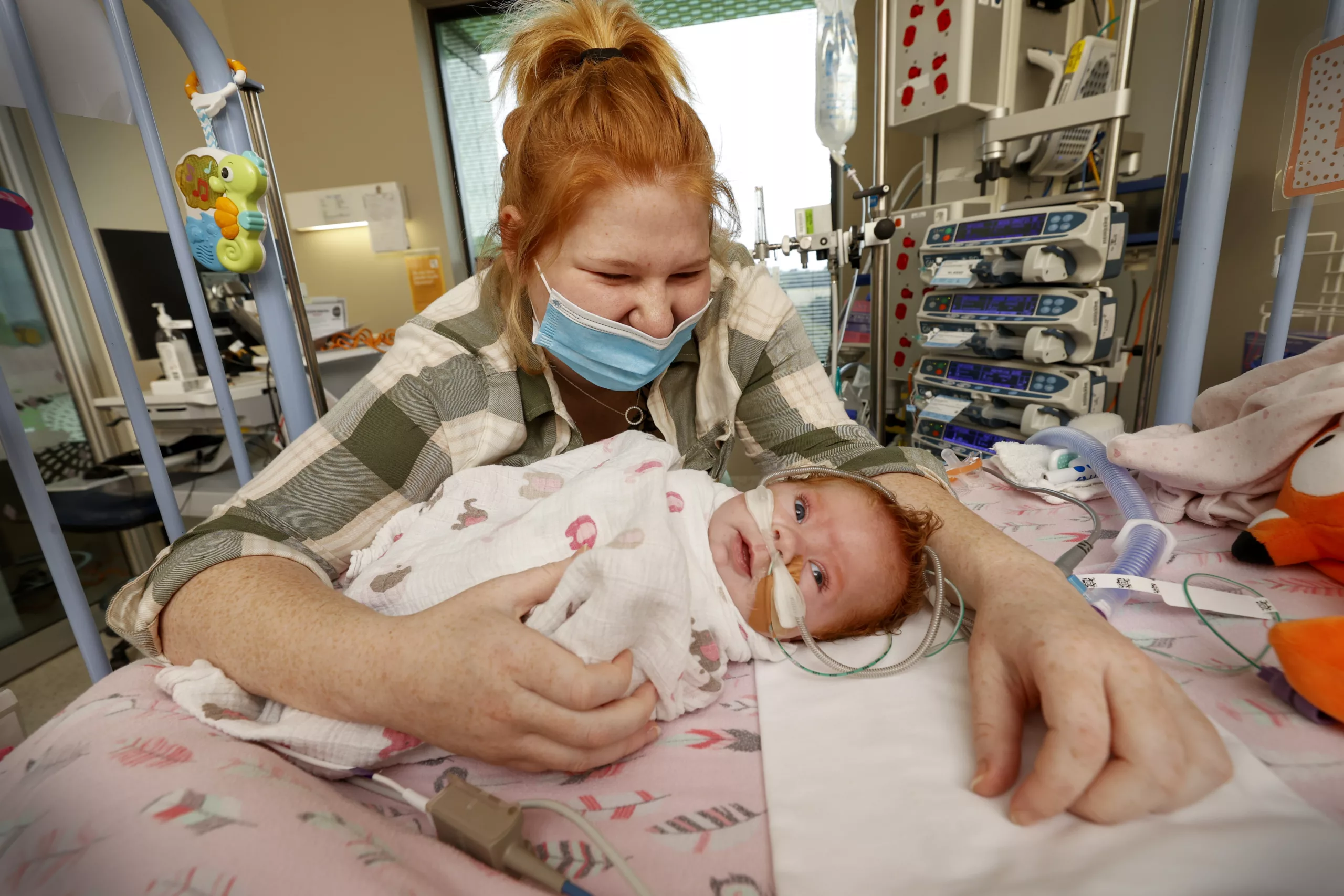 Image of Baby and his Mum wearing a face mask at the RCH Taken by Alex Coppel in 2022